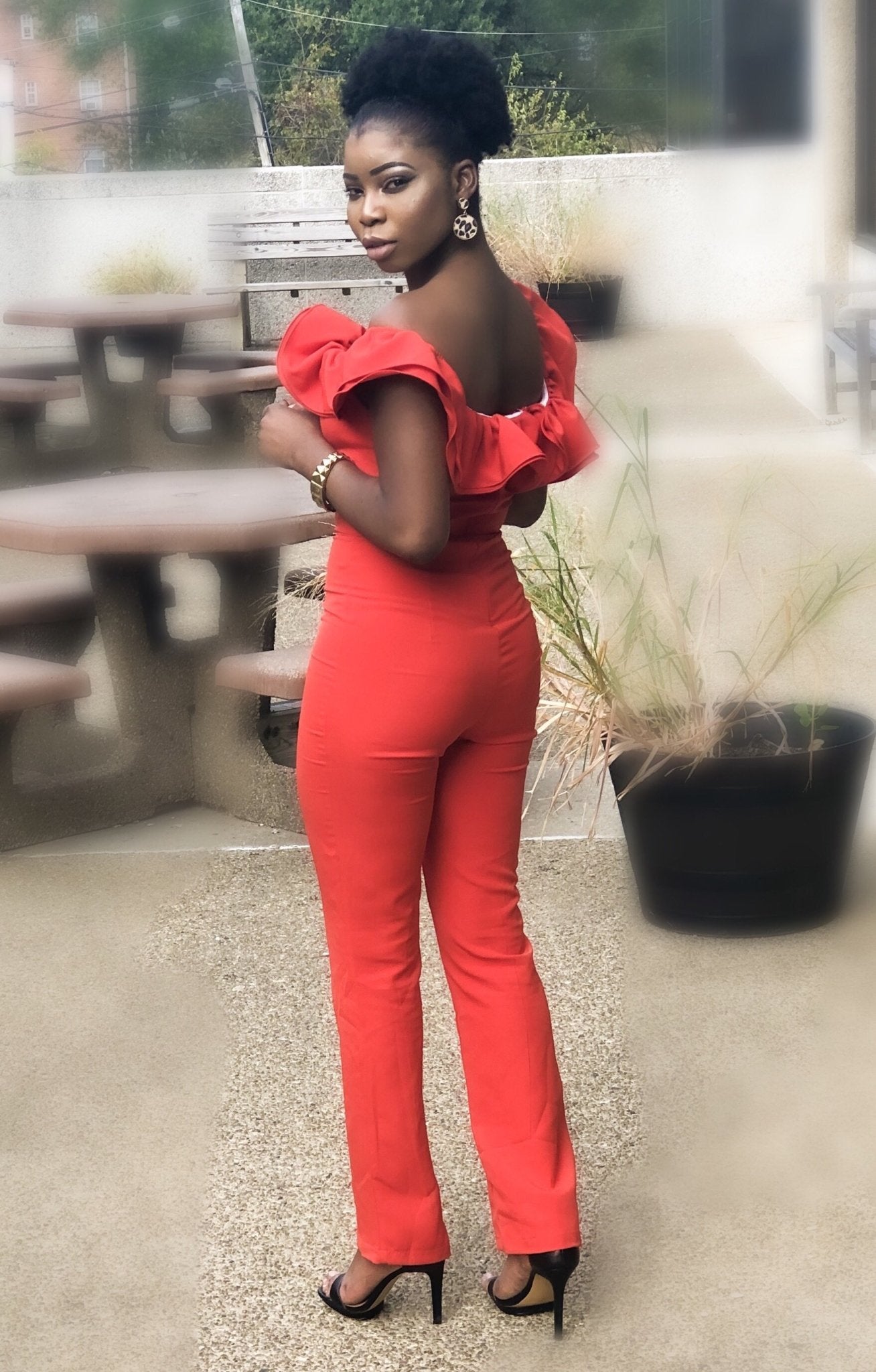 a woman in a red dress on a street 
